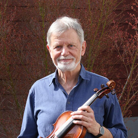 Ulrich Giese steht mit seiner Geige im Freien