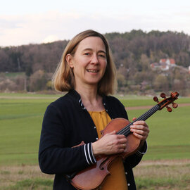 Brigitte Ott-Richard steht mit ihrer Geige im Freien